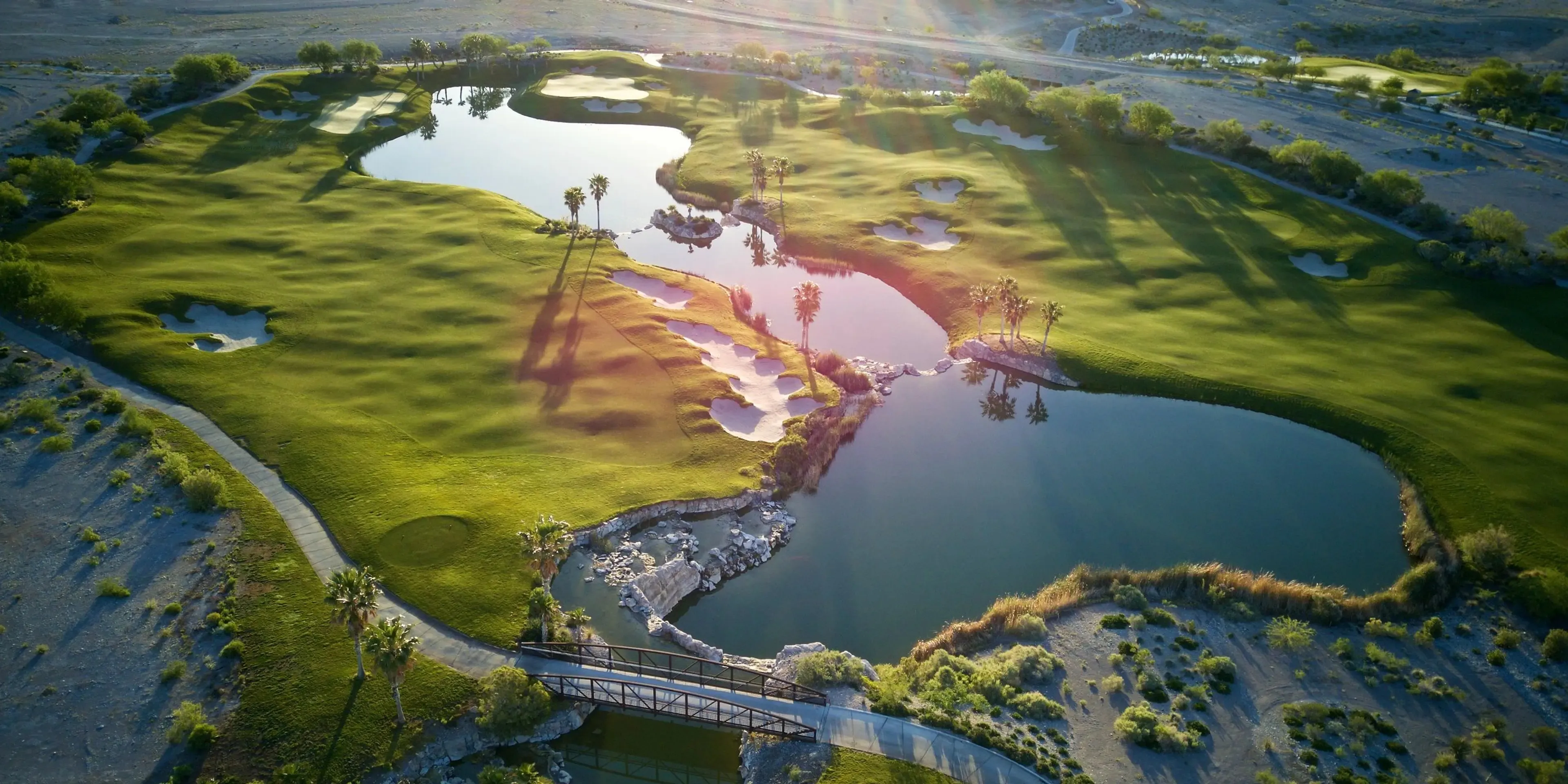 Coyote Springs golf hole with water hazard lake and desert mountains in background